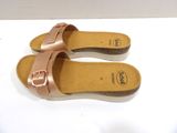 pair of women ' s rose gold sandals on a white surface