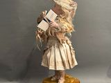 a doll that is holding a book on a box