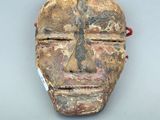 une image représentant un masque en bois sur un fond blanc