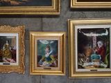 many framed pictures on the wall of this room