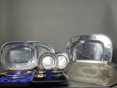 a lot of silver plates and trays sitting on a table