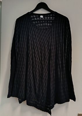 the shirt is hanging on a hanger on the wall
