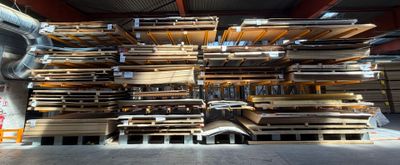 un gros tas de palettes en bois dans un entrepôt