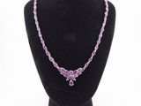 a necklace with purple beads on a black mannequin
