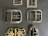 four antique belt buckles and a belt buckle with a flower design