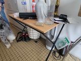 a dog standing next to a table with a vase on it
