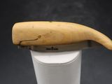 un objet en bois en forme de baleine posé sur une tasse blanche