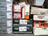 Plusieurs cartons contenant du matériel électronique sont empilés les uns sur les autres par terre.