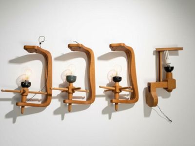 trois appliques en bois fixées au mur à côté d'une lampe