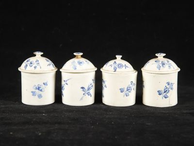 four blue and white canisters sitting on a black surface