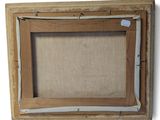 an old picture frame with a piece of linen hanging on the wall