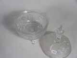 a glass bowl with a lid and a glass bowl with a lid sitting on a table