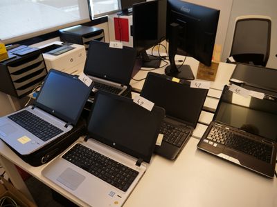 de nombreux ordinateurs portables posés sur un bureau dans une pièce
