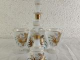 five glasses sitting on a table with a vase on top of it