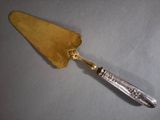 a silver and gold spoon with a gold handle on a table