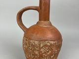 a brown vase that has a handle on it