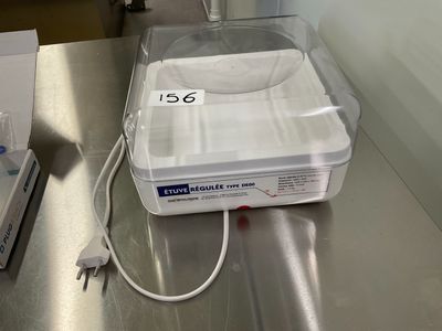 un récipient en plastique muni d'un couvercle, posé sur une table en métal