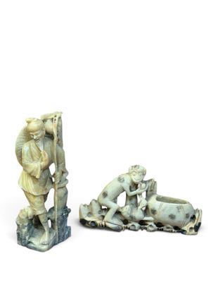 two ivory figurines of a man and a woman on a boat