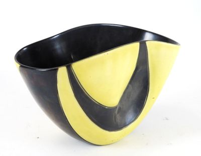 a black and yellow bowl sitting on a white surface