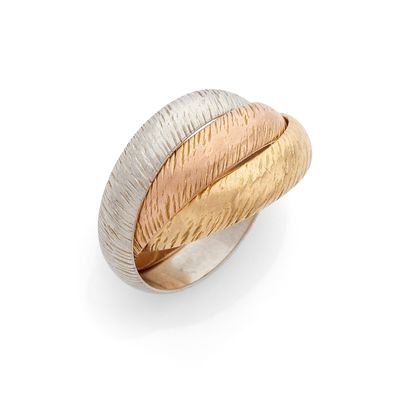 gros plan d'une bague en or et en argent sur une surface blanche