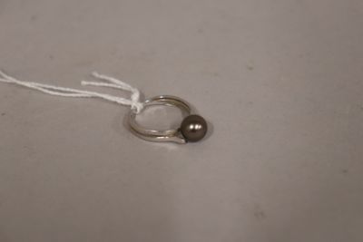 a silver ring with two brown beads on a white string
