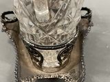 a silver plate with a crystal vase on it