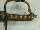 a close up of a sword on a white surface
