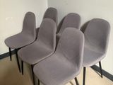 four grey chairs are lined up against a wall in a room