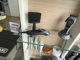 une étagère en verre sur laquelle sont posés des sèche-cheveux et d'autres objets