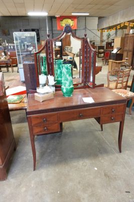 une table sur laquelle se trouvent un miroir et un vase