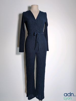 the woman is wearing a blue jumpsuit with a long sleeve