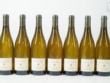 six bouteilles de vin sont alignées sur une surface blanche
