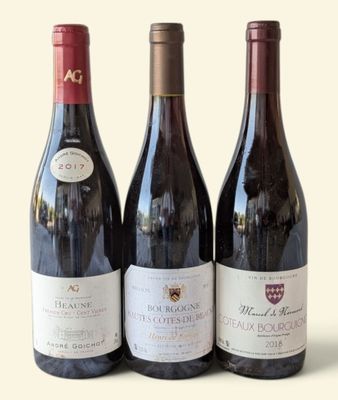 three bottles of wine are lined up on a white surface