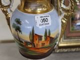 a vase with a painting on it sitting on a table