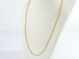 a gold chain necklace on a mannequin head