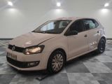 la volkswagen polo blanche est garée dans une pièce au sol à carreaux