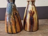 two vases that are sitting on a wooden table
