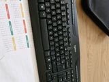 a keyboard and mouse on a desk next to a notebook