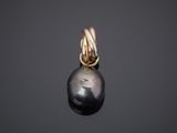 a black pearl and gold pendant on a black background