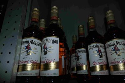 Plusieurs bouteilles d'alcool sont alignées sur une étagère dans un magasin