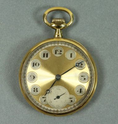 une montre de poche en or avec des chiffres sur le cadran