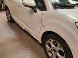 a picture of a small white car parked in a garage