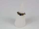 an image of a ring with a blue stone sitting on top of a white cone