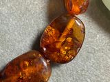 necklace made of glass beads with orange and green colors on a table