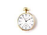 a close up of a pocket watch on a white surface