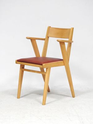 une chaise en bois avec une assise rouge sur fond blanc