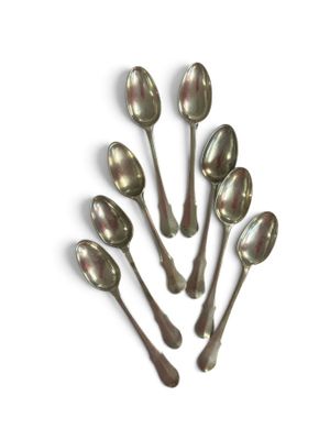 six spoons are arranged in a circle on a white surface