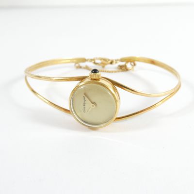 un gros plan d'une montre-bracelet montée sur un bracelet en or