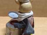 a figurine of a chef with a pot and pan on top of it