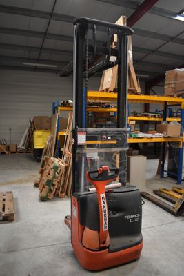 a fork lift truck in a warehouse with pallets in the background
